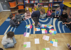 Dzieci siedzą w kole podczas zajęć matematycznych.