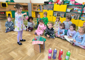 Dziewczynka miesza farbę w plastikowym kubku