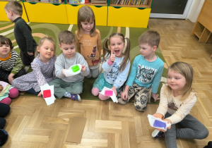 Dzieci trzymają kolorowe kostki lodu