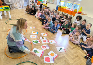 Dzieci patrzą na obrazki ułożone na podłodze