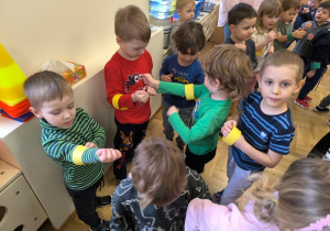 Dzieci oglądają kolorowe opaski założone na ręce