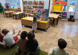 Dziewczynka przykleja naklejkę na plakat