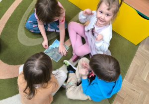 Dzieci układają obrazek przedstawiający dinozaura