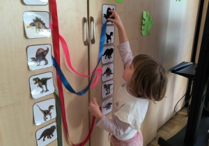 Dziewczynka przyczepia wstążkę do obrazka