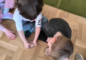 Chłopiec odciska w masie solnej sylwetę dinozaura