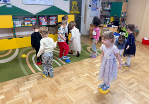 Dzieci stoją na gumowych kamieniach sensorycznych