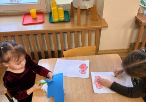 Dziewczynka wycina doniczkę z kolorowego papieru