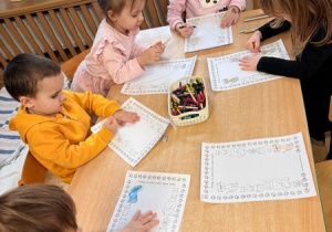 Dzieci kolorują obrazki przedstawiające koty