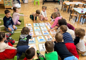 Dzieci wskazują obrazki przedstawiające postaci reprezentujące różne zawody