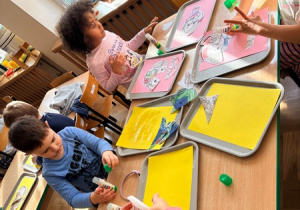 Dzieci przyklejają elementy obrazka