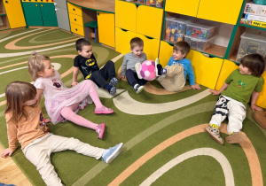 Dzieci podają sobie piłkę za pomocą stóp