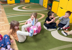 Dzieci podają sobie piłkę za pomocą stóp