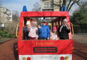 Dziewczynki pozują do zdjęcia w ogródku przedszkolnym.