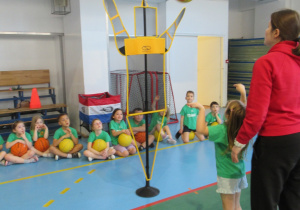 Dziewczynka rzuca piłkę do kosza.