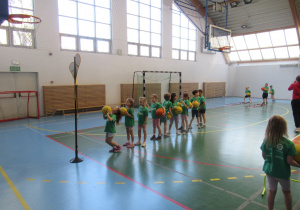 Dzieci ćwiczą na zajęciach koszykówki.