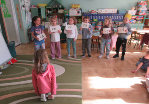 Dzieci trzymają rękach tabliczki z sylabami.