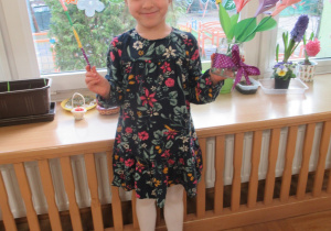 Dziewczynka prezentuje kwiaty wykonane podczas warsztatów.