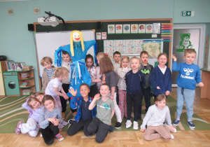 Dzieci pozują do zdjęcia z Marzanną wykonaną na zajęciach.