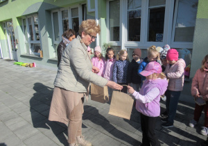 Pani Dyrektor wręcza dziewczynce nagrodę za udział w konkursie Moja Marzanna.