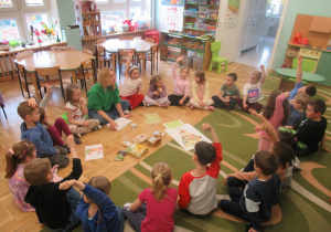 Dzieci siedzą w kole podczas zajęć.