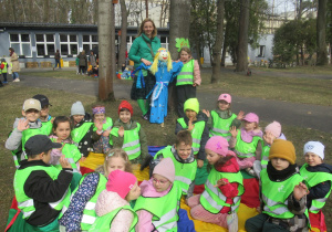 Dzieci siedzą na chuście, dziewczynka z panią stoją obok Marzanny.