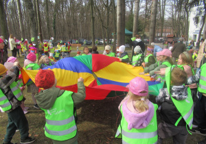Dzieci trzymają chustę animacyjną podczas zabaw na powitaniu wiosny w MDK "Bielany".