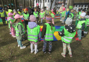 Dzieci stoją wokół chusty animacyjnej.